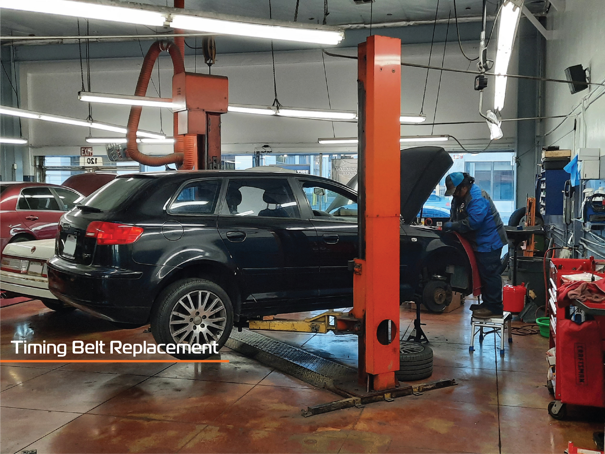 This mechanic is replacing the timing belt on a black Audi